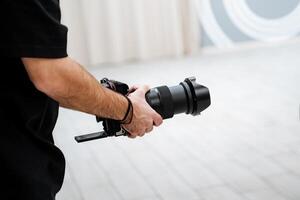 A videographer shoots a report at an event, a person holds a camera in his hands, a folding screen of equipment. photo
