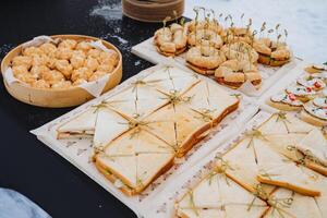 Triangular sandwiches lying on the table outside, catering on the road, outdoor event, food in the cold in winter. photo