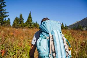 Camping equipment, backpack for things, rear view, hiking in the mountains with a trunk, straps on the backpack, trekking equipment, rear view of the tourist. photo