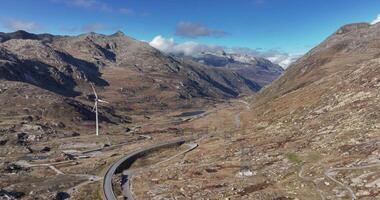 Drone pan over Gotthard Pass in Switzerland with surrounding mountains and wind turbines video