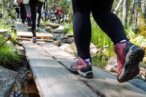 Hiking shoes for hiking, trekking boots, man walking on bridge, feet shot close-up, sports shoes for traveling. photo