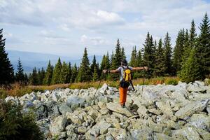 A guy is standing in the mountains with his arms outstretched to the sides, a kurum river is on top of a mountain, a tourist is standing in the mountains alone to admire the view, trekking photo