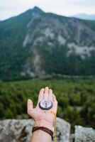 Orienteering on the terrain with a compass, a navigation device for extreme situations, a magnetic needle points north. photo