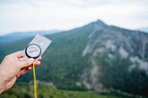 The hand holds the compass, the path along the azimuth to the north, the arrow indicates the direction of movement. photo