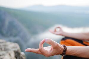 Hands close-up fingers folded into chinmudra, wise for meditation, balance of the inner world, Zen practice in nature, silence of inhalation, bracelet on the arm. photo