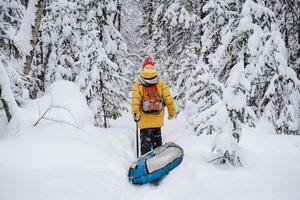 brave traveller. hiking backpack on the back of the traveler. Snowy forest and rocks. Climbing the mountain in winter. Survival in the wild. photo