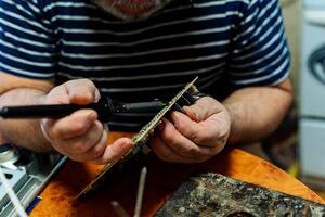 Hands solder electronics chip. Finely handmade. Soldering iron in hand. photo