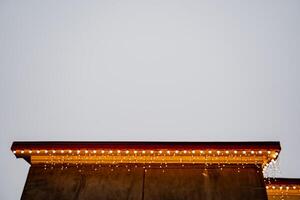 A christmas tree is lit up on top of a building photo