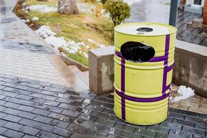 A yellow trash can with purple and black stripes photo