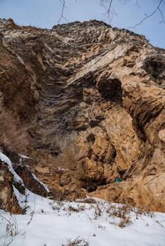 A man is standing on a rock in the snow photo