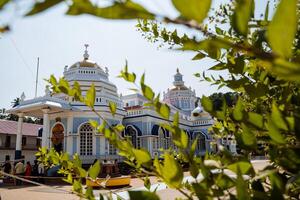 An Indian temple of blue color in clear weather. Goa pilgrim's journey through holy places. Beautiful ashram. A place of worship for the god Shiva. photo