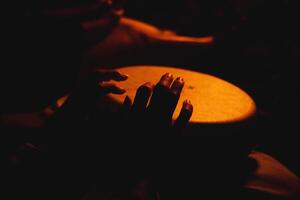 A close shot of the hands of a man playing a melody on ethnic drums photo