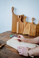 the carpenter draws a sketch of the future product, the carpenter's hand holds a pencil, a cutting board photo