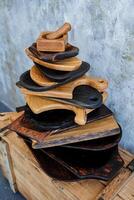 A set of wooden utensils. A mountain of plates in the carpentry workshop. handmade wood products by a carpenter. photo
