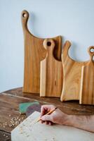 The carpenter draws with a pencil on the board. hand holds a pencil, carpentry workshop, sketch of the future product photo
