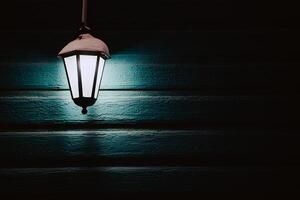 hanging street lamp shines in the darkness photo