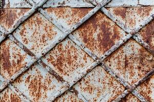 pattern rusty rhombus. old door surface. worn metal background photo