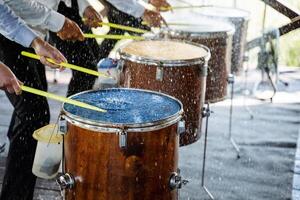 Drums stand in a row. drumsticks. drummers. splashes of water on the membrane photo