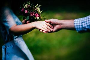 Close-up of a woman and a man holding out their hands, two people holding hands. The symbol is a sign of sincere feelings, a loved one. the concept of true friendship, outdoors photo