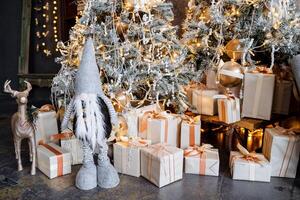 A mountain of gifts under a decorated Christmas tree, next to a grandfather's and a toy deer. New Year and Christmas mood, preparations for the holiday photo