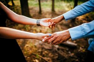 Close-up of a woman and a man holding out their hands, two people holding hands. The symbol is a sign of sincere feelings, a loved one. the concept of true friendship, outdoors photo