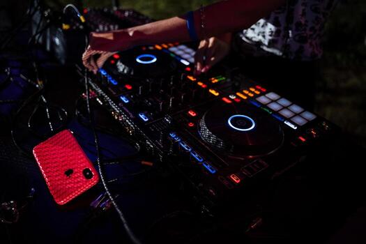 DJ remote control at a party, a device with colored buttons for playing music, blurred background, close-up, life style photo