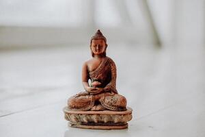 Buddha figurine ceramic brown color, the attributes on the subject of yoga, a symbol of peace and tranquility, Zen photo