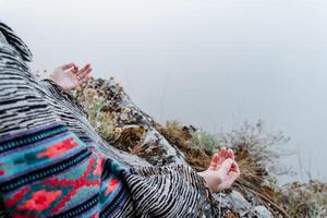 fingers folded in mudra against the background of mountains and fog, a state of peace and tranquility, Zen, yoga in nature photo