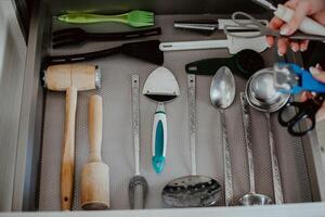 A set of Cutlery in a drawer. Correct placement of knives, forks and spoons in the drawer. Order in the kitchen. The concept of order in the house. photo
