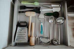 A set of Cutlery in a drawer. Correct placement of knives, forks and spoons in the drawer. Order in the kitchen. The concept of order in the house. photo