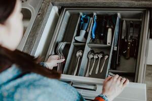 A set of Cutlery in a drawer. Correct placement of knives, forks and spoons in the drawer. Order in the kitchen. The concept of order in the house. photo