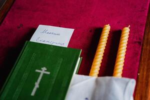 Church book the Bible is on the table in the temple, items for the wedding ceremony, candles, cross, close-up photo