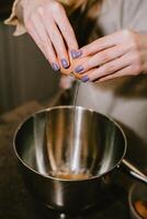 Break an egg into a saucepan. A girl breaks eggs in a bowl to make pastries. The process of baking with your own hands. photo