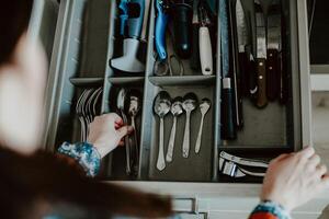 A set of Cutlery in a drawer. Correct placement of knives, forks and spoons in the drawer. Order in the kitchen. The concept of order in the house. photo