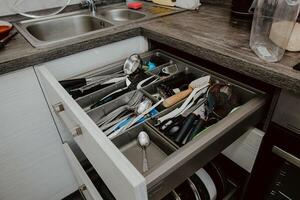 A set of Cutlery in a drawer. Correct placement of knives, forks and spoons in the drawer. Order in the kitchen. The concept of order in the house. photo