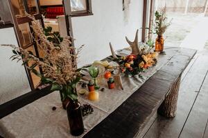 boho style in wedding decoration, table decorated in rustic style, rustic house, flowers horns tableware on the table, eco style, table setting, Scandi style photo