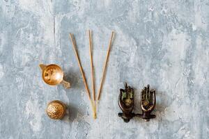 metal door handles in the shape of hands folded in mudra, shot on a textured gray background, close-up, separate object, yoga theme, bronze hue, Indian motif, incense photo