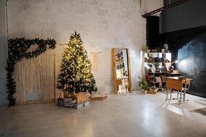 A room with a christmas tree and a desk photo