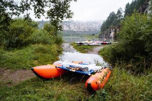 sports catamaran for rafting on mountain rivers, Hiking equipment, inflatable catamaran stands on the river Bank, the concept of outdoor activities. photo