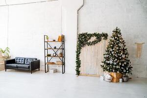 A room with a christmas tree, a couch and a table photo