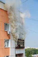 fire on the balcony of a multi-storey building, black clouds of smoke, apartment smoke, extinguishing fire in a residential building, fire escape, emergency photo
