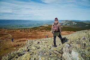 A person standing on a rocky hill with a backpack photo