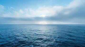 A vast expanse of blue ocean stretches to the horizon under a sky filled with fluffy white clouds. photo
