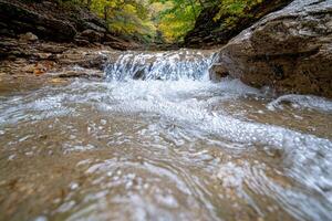 Cascading waterfall in autumn forest photo