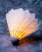 Glowing feathered shuttlecock on snowy surface photo