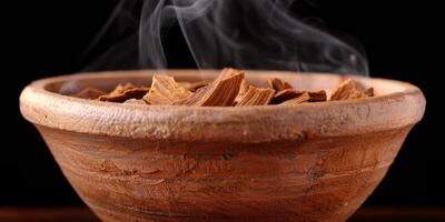 Smoldering wood chips in a rustic wooden bowl photo