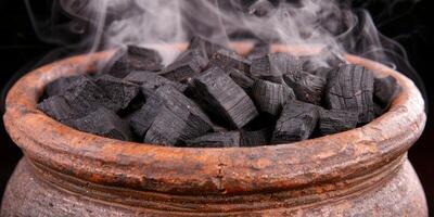 Smoldering charcoal in a rustic bowl photo