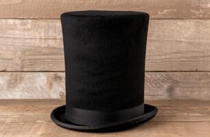 black top hat on wooden background photo