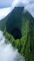 Lush green mountain peak in the clouds photo