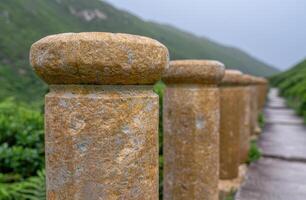 Weathered stone pillars in a lush green landscape photo